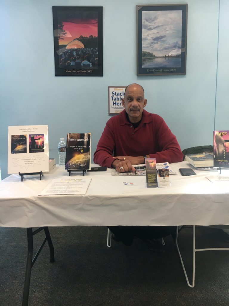 Author sitting with his works at author event